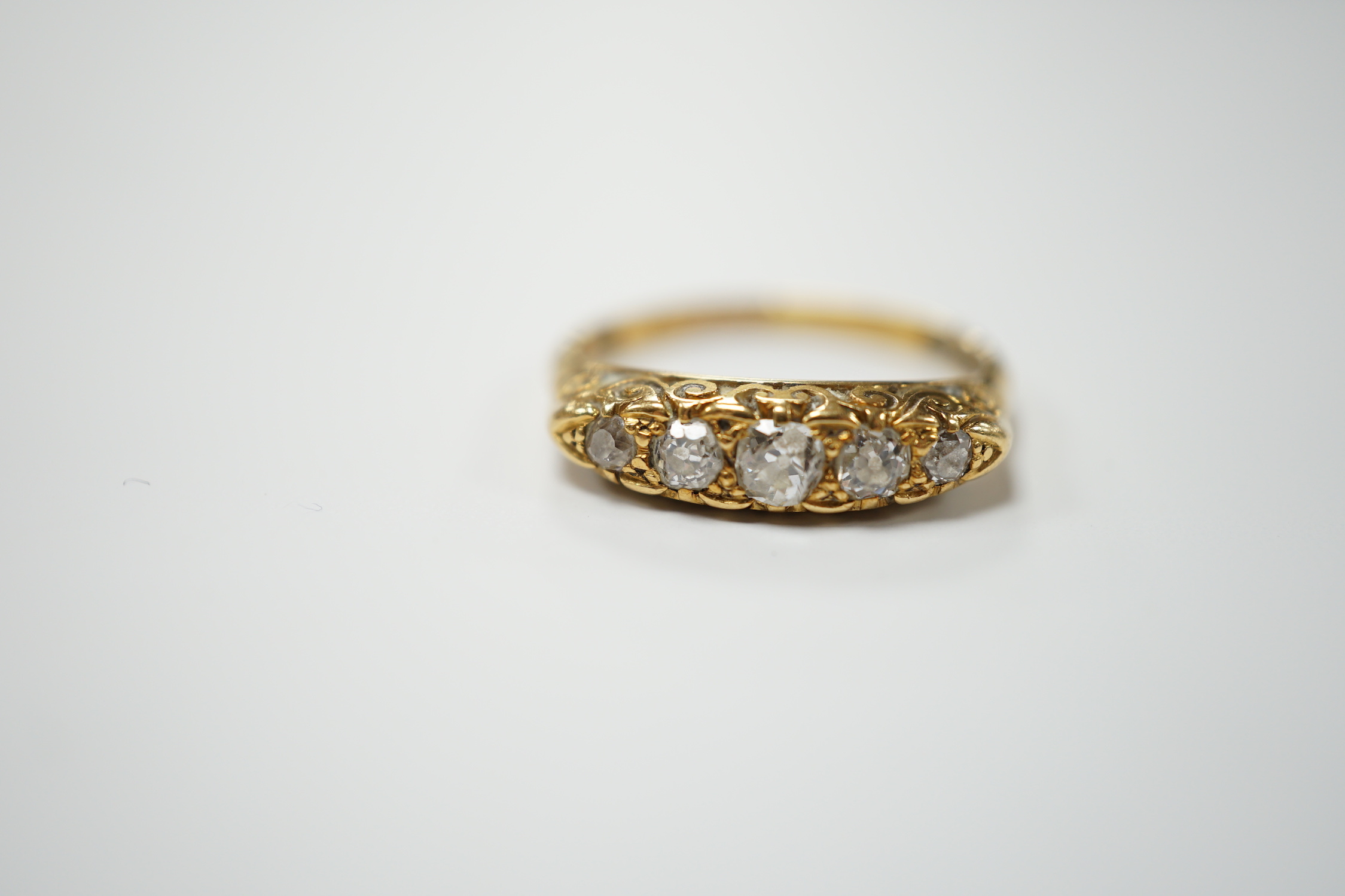 An Edwardian 18ct gold and graduated five stone diamond set half hoop ring. size R, gross weight 4.4 grams.